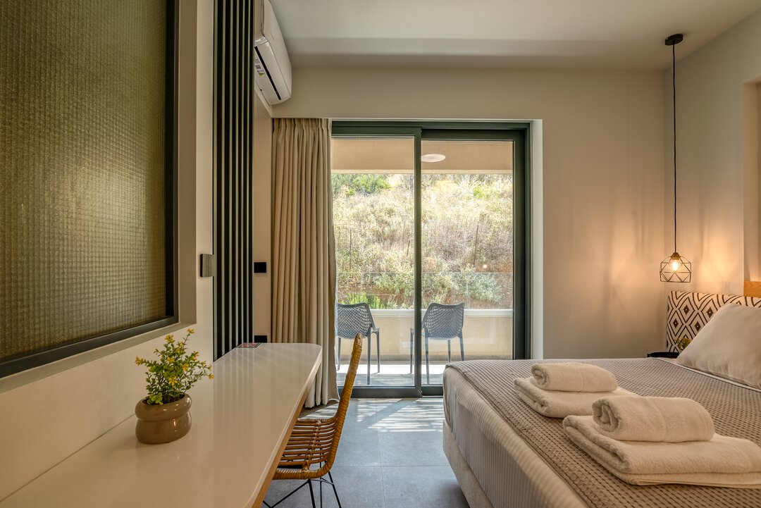 Elegant bedroom with upholstered headboard, matching nightstands, and sophisticated neutral palette at Nusa Gramvousa, Crete