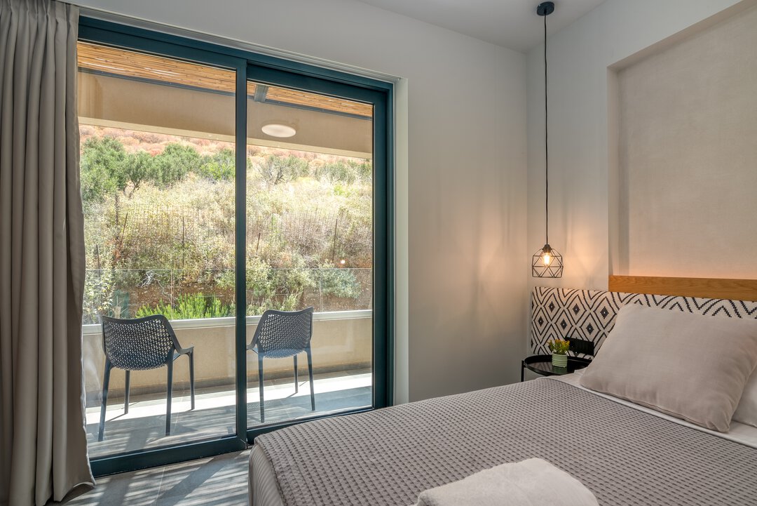 Charming bedroom with textured bedding, black metal nightstand, and warm wood tones at Nusa Gramvousa, Kissamos, Crete