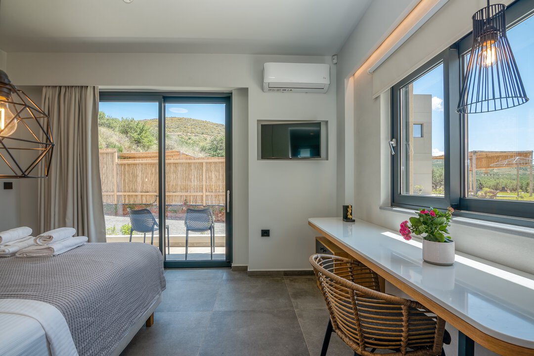 Cozy double room with comfortable bed, geometric accents, and warm lighting at Nusa Falassarna, Crete