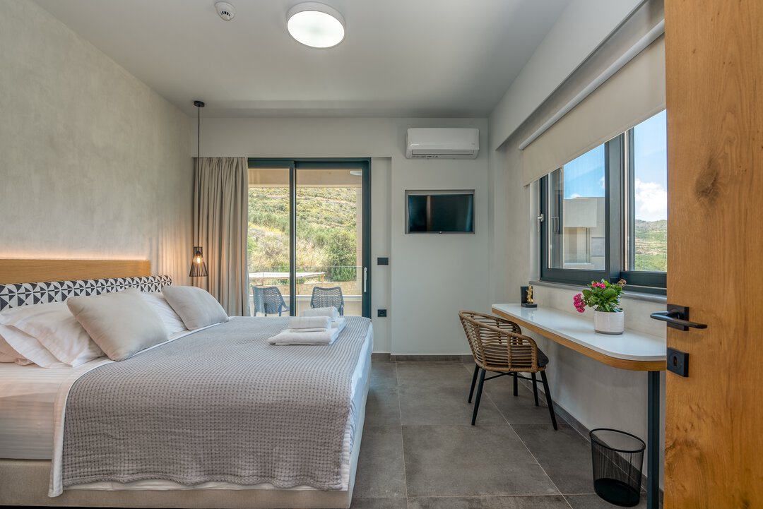 Open plan kitchen and dining area with modern appliances and elegant table setting at Nusa Falassarna, Crete