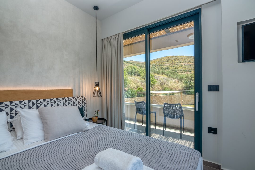 Indoor dining area with rattan chairs and garden views at Nusa Falassarna, Crete