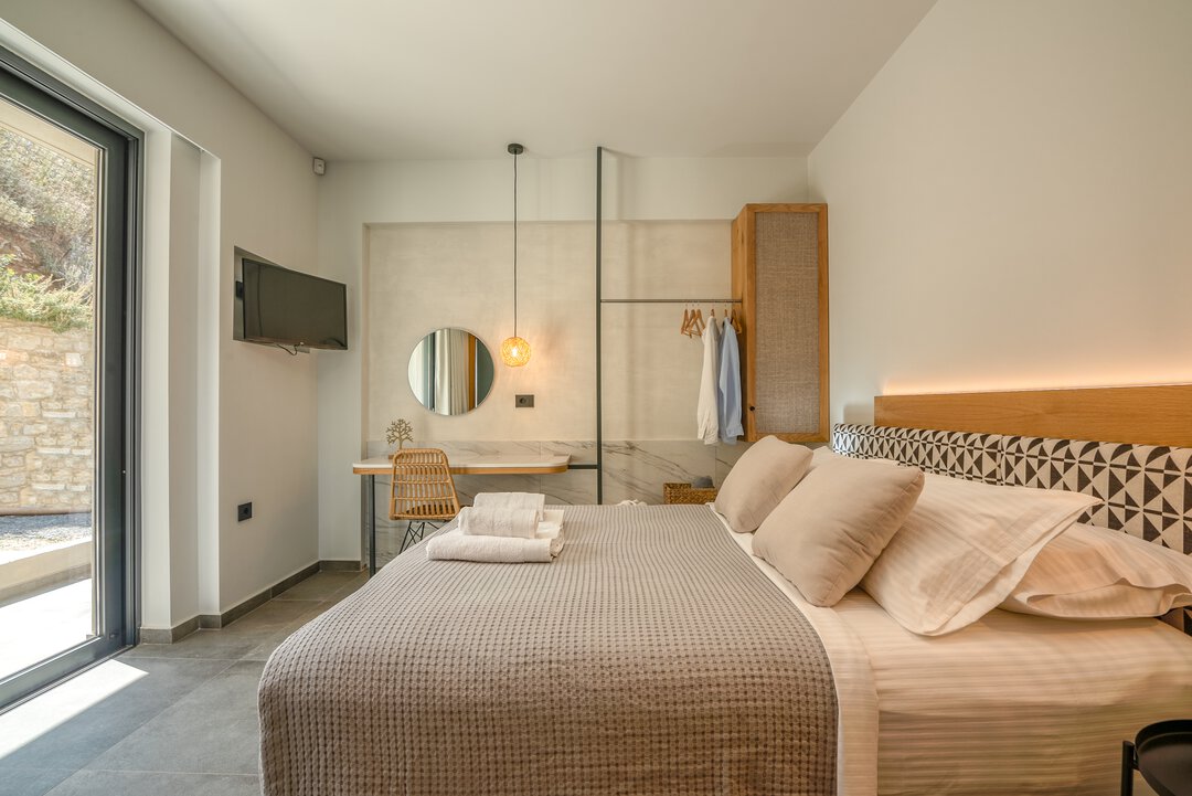 Contemporary guest bedroom with geometric headboard, quality linens, and modern furnishings at Nusa Balos villa, Crete