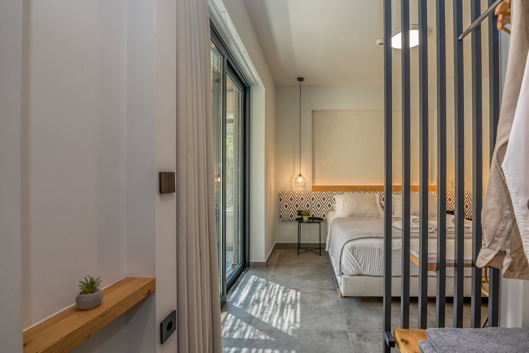 Second bedroom with open wardrobe and sliding bathroom door at Nusa Balos villa, Crete